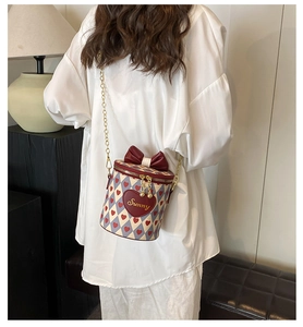Close-up of heart-patterned bucket bag with red bow and Sunny embroidery on the front