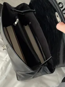 Detail view of the spacious inner compartment with books and metal zipper pocket