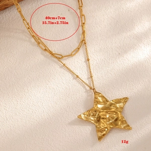 Detail view of 18k gold star pendant necklace with hammered texture and size specs