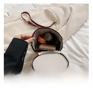 Interior view of wine red bucket bag showing storage capacity for phone and cosmetics