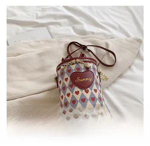 Detail showing contrast chain bucket bag with heart pattern and Sunny leather patch