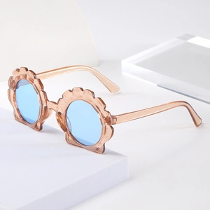 Detail of shell-shaped kids sunglasses with glitter amber frame and blue lenses