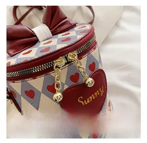 Close-up of golden dual-way metal zippers and chains on a heart pattern bucket bag