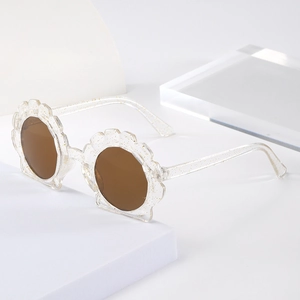 Detailed shot of shell-shaped kids sunglasses with transparent glitter resin frames