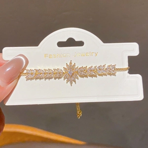 Detail of 18k gold plated bracelet showing marquise cubic zirconia floral center and leaf chain