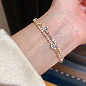Detailed view of layered 18k gold plated tennis bracelet with sparkling zircon stones