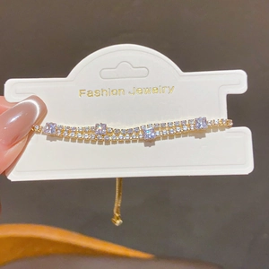 Detail of adjustable double-layer tennis bracelet with gold finish and zircon stones