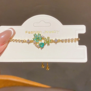 Detail of 18k gold plated flower bracelet with green gems and adjustable drawstring clasp