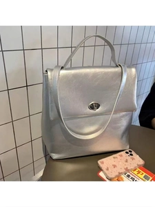 Minimalist silver oil-wax leather backpack with metallic finish and circular twist lock