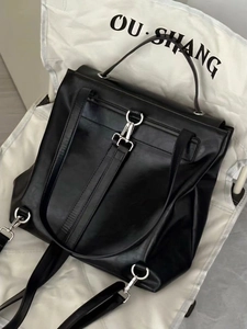 Versatile black waxed leather backpack for women with silver metal buckles on white chair