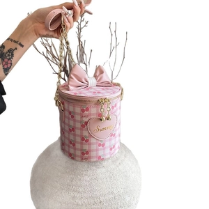 Pink and white checkered cylinder bucket bag with cherry print and bow chain strap