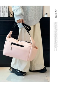 Dettaglio tracolla regolabile e fibbia su borsa a tracolla in nylon rosa con tasca