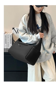 Dettaglio borsa a tracolla in nylon nero con tracolla larga e tasche multifunzione