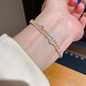Close-up of 18k gold plated double-layer tennis bracelet with sparkling square crystals