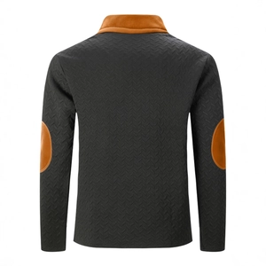 Gros plan d'un polo pour hommes avec texture à chevrons gris foncé et empiècements orange vif