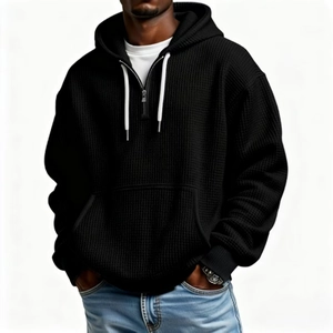 Détail d'un sweat à capuche noir en maille gaufrée avec demi-zip et cordons blancs