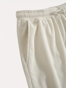 Detailed macro view of cream waffle knit fabric with drawstring elastic waistband