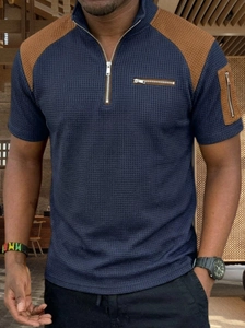 Detailed close-up of dark blue waffle knit texture and brown fabric patchwork on sleeve