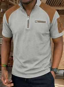 Close-up of men's grey waffle knit polo shirt with brown contrast panels and metal zippers
