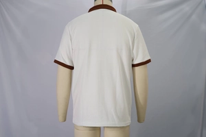 Detailed view of the waffle texture fabric and contrast brown collar on a white polo shirt