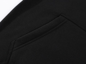 Close-up of a black casual hoodie featuring a high-density kangaroo pocket with clean stitching