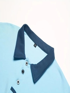 Dettaglio della polo in cotone piqué azzurro con colletto a contrasto blu e etichetta M
