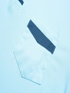 Dettaglio del tessuto in maglia piqué blu con tasca dal design a colori contrastanti
