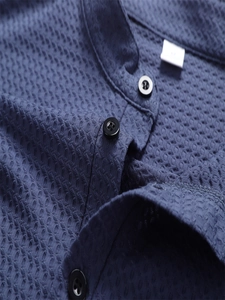 Makroaufnahme von navy Poloshirt mit Waffelstruktur und schwarzen Knöpfen im Detail