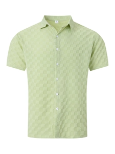 Detail of light green short sleeve shirt showing textured knit and 100% polyester label