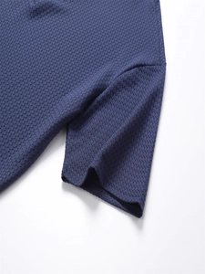 Detailaufnahme des dunkelblauen Polo-Shirts mit atmungsaktiver Waffelstruktur und Seitennähten