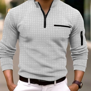 Détail du polo à manches longues gris à damier avec fermeture éclair au bras et texture