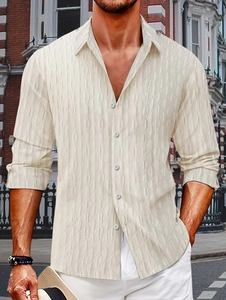 Detailed close-up of beige men's casual shirt featuring textured geometric jacquard fabric