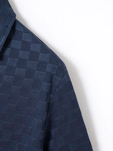 Close-up of dark blue men shirt showing checkered jacquard texture and collar detail