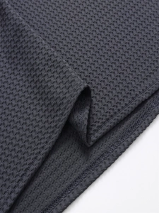 Makroaufnahme von dunkelgrauem Poloshirt mit Waffelstruktur und Saumnähdetails