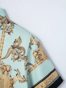 Detailansicht des hellblauen Hemdes mit goldenen Pferden und Barock-Blumenmustern