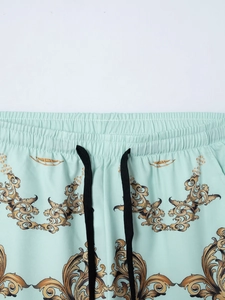 Detailansicht von elastischem Bund und Barock-Print auf hellblauen Strandshorts