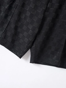 Detail shot of the black checkerboard jacquard texture and knit fabric on men shorts