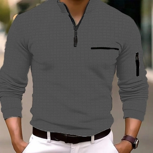Vue détaillée du polo gris foncé gaufré avec col zippé et poche sur la manche gauche