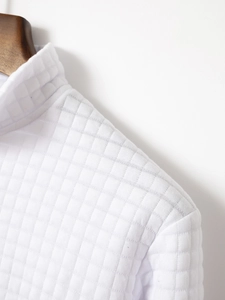 Vue détaillée du tissu gaufré blanc sur un polo à col montant au design minimaliste