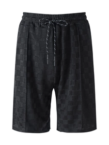Detail of black ice silk shorts featuring textured checkerboard jacquard and drawstring waist