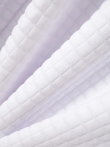 Vue détaillée du tissu en maille gaufrée blanche avec texture quadrillée et côtes douces