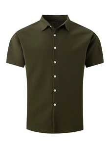 Detailed macro view of green waffle knit texture on a short sleeve casual shirt