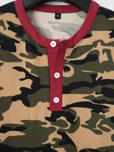 Detail of waffle knit fabric and camo print with burgundy collar on a men's polo shirt