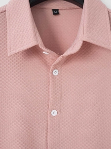 Detailed close-up of pink waffle texture fabric and collar on men's short sleeve shirt