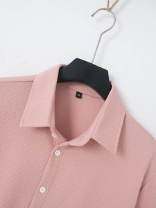 Detailed close-up of waffle knit fabric and lapel on a lotus pink short sleeve shirt
