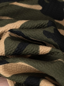Macro shot of breathable honeycomb texture and jungle camouflage pattern on a polo shirt