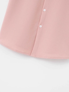 Close-up of pink waffle texture fabric with white buttons and curved hem on men shirt