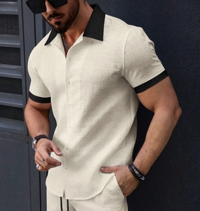 Detail view of men's cream short sleeve shirt featuring black contrast collar and cuffs