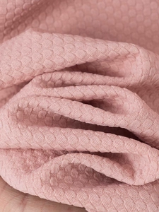 Close-up of pink men's shirt featuring 3D honeycomb textured breathable fabric