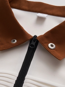 Detail of men's polo shirt with waffle texture brown collar and white honeycomb fabric